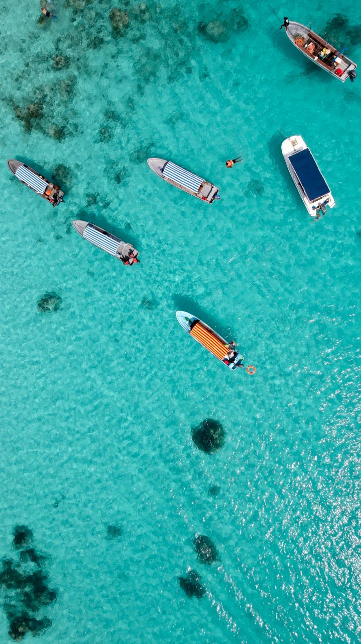 Aerial view of snorkelling boats over a coral reef in turquoise water