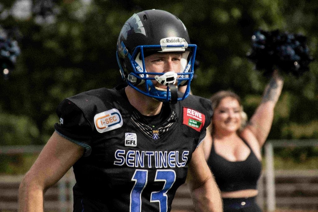 Frankfurt Sentinels American football quarterback with cheerleader behind