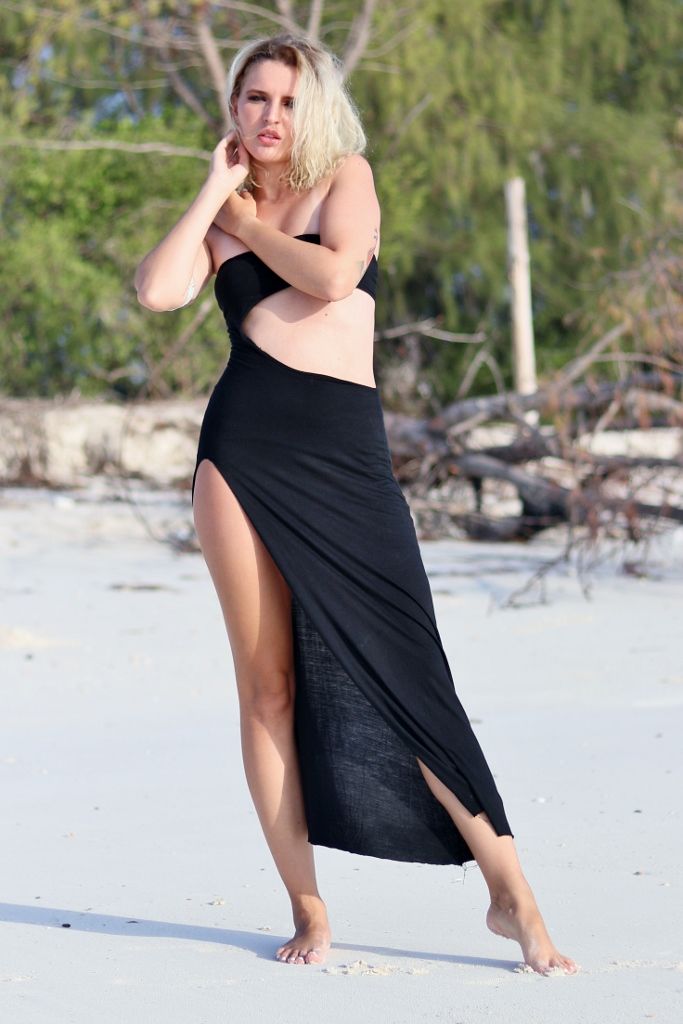 Beach portrait of a woman in a black side-cut gown on white sand