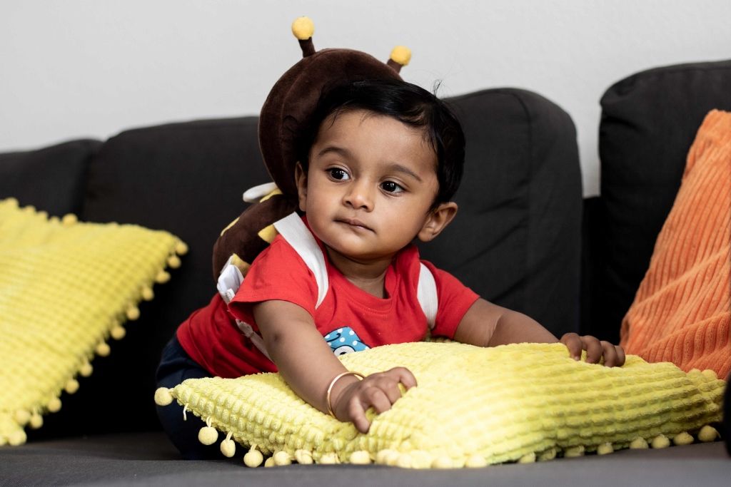 Indoor portrait of a baby in a costume hat on a couch