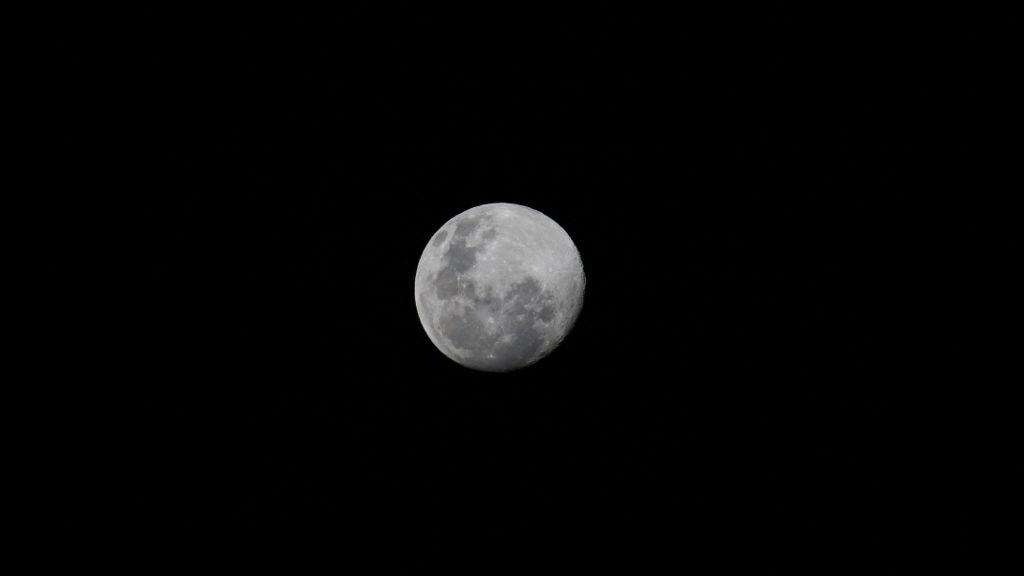 Telephoto photograph of a near-full moon at night