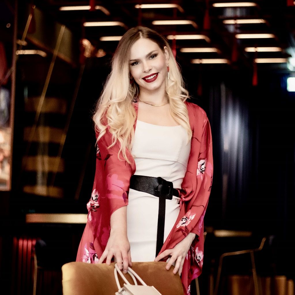Evening portrait of a woman in a white dress and floral kimono in a bar