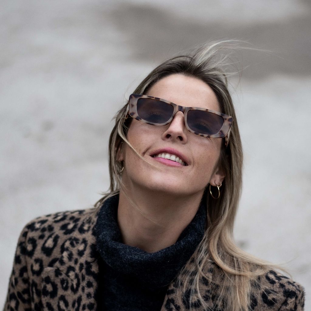 Winter portrait of a woman in a leopard print coat and tortoiseshell sunglasses