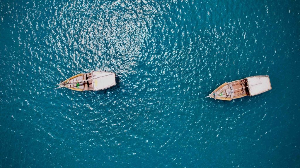 Aerial view of two boats drifting on deep blue ocean water